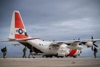 An HC-130 Hercules airplane crew offloads supplies in Saipan.